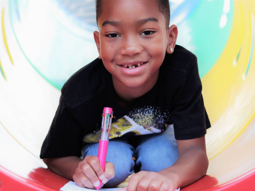 K-12 student on playground writing